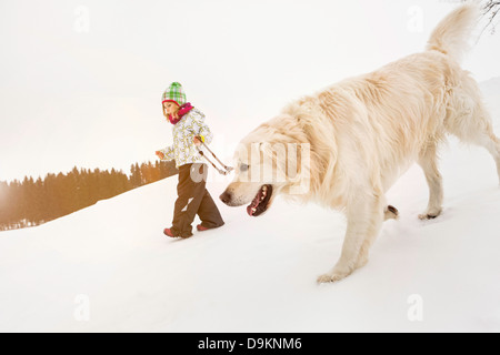 Girl walking dog in snow