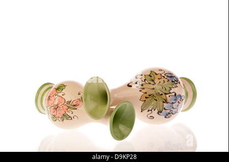 Two toppled decorated vases with pink flowers, green leaves and purple grapes isolated on white Stock Photo
