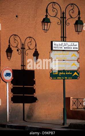 Shadow of a lamp-post which has writing on it.  This is the entrance to Marrakesh Medina. Stock Photo