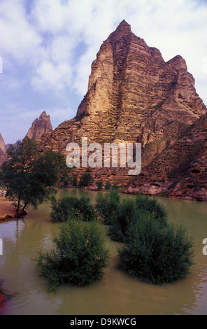 Massive cliffs in the Liujiaxia Reservoir formed by the Liujiaxia Dam on the Huang He or Yellow River.around Bingling Si Buddhist grottoes located entirely within Linxia Hui Autonomous Prefecture in Gansu province China Stock Photo