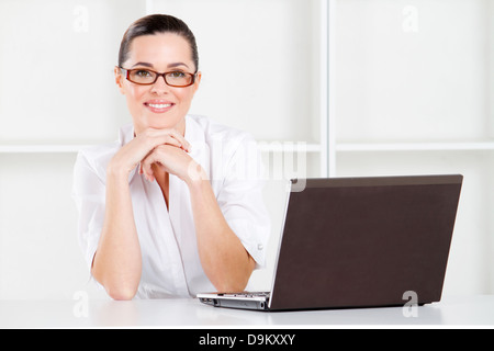 good looking young businesswoman sitting in office with laptop Stock Photo