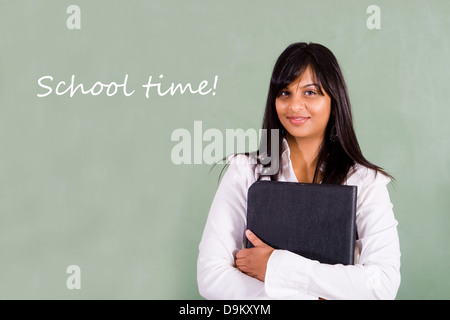 beautiful young Indian school teacher standing in front of blackboard Stock Photo