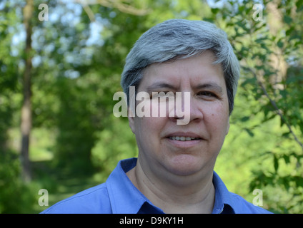 Close up of middle aged woman looking directly at camera, in garden Stock Photo