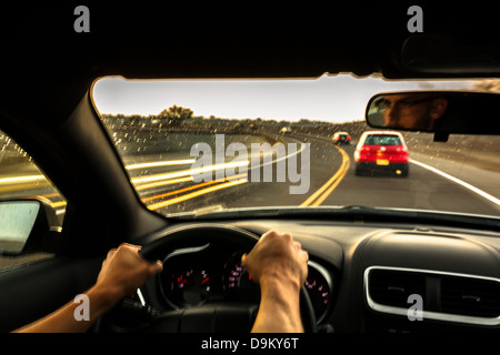 Mid adult man driving car at speed Stock Photo