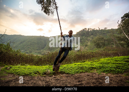 Mid adult man on rope swing Stock Photo