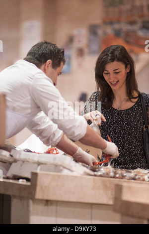Woman buying fresh fish in market Stock Photo