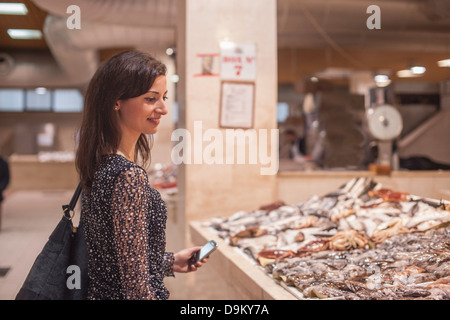 Woman looking at fresh fish in market Stock Photo