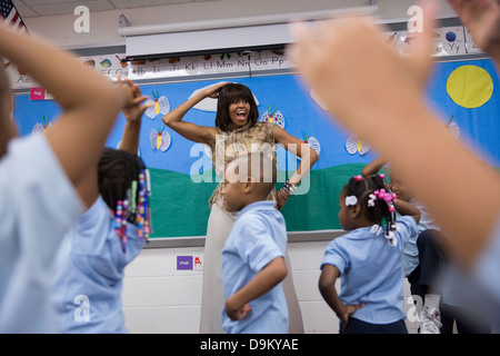 US First Lady Michelle Obama dances with students during a classroom visit at Savoy Elementary School May 24, 2013 in Washington, DC. Savoy is one of eight schools selected for The Turnaround Arts Initiative at the President's Committee on the Arts and the Humanities. Stock Photo