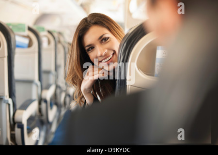 Female passenger turning around on aeroplane Stock Photo