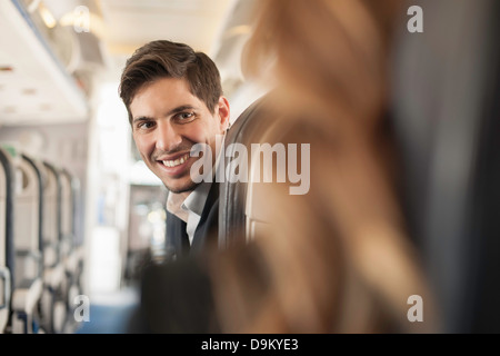 Male passenger turning around on aeroplane Stock Photo