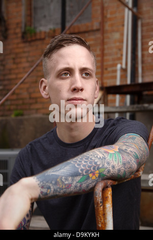 Young tattooed man looking away Stock Photo