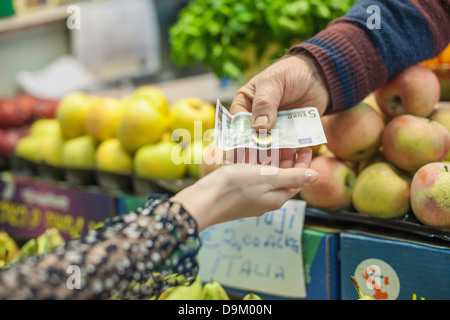 Shopkeeper handing change to female customer in market Stock Photo