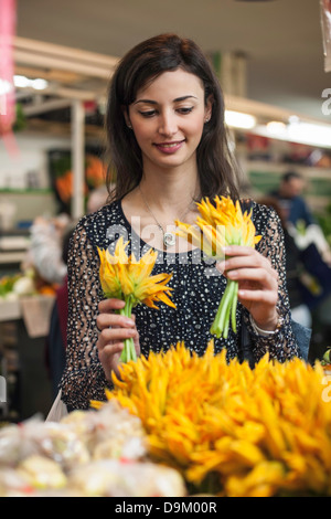 Woman choosing yellow flowers in market Stock Photo