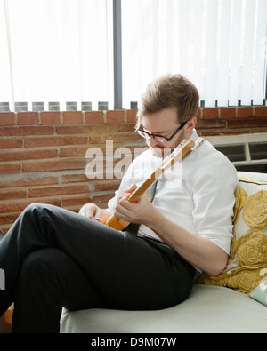 Young man practising on electric guitar Stock Photo