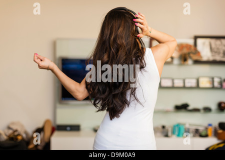 Mid adult woman wearing headphones and dancing, rear view Stock Photo