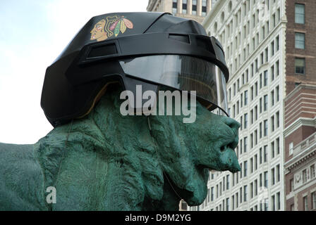 Chicago, Illinois, USA. 17th June, 2013. Art Institute of Chicago Lions wear Chicago Blackhawks' helmut as a show of support for Chicago's hockey team battling against the Boston Bruins for the Stanley Cup. The bronze statues guarding the entrance to the museum wore Hawks' helmut in 2010 when the Blackhawks brought home the Stanley Cup trophy. On other occasions, the Lions have donned White Sox hats and Chicago Bears helmets to honor Chicago's winning teams. ©Karen I. Hirsch/ZUMAPRESS.com/Alamy Live News Stock Photo