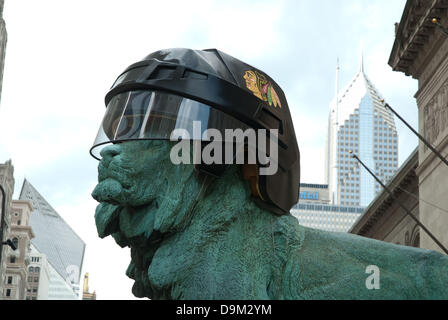 Chicago, Illinois, USA. 17th June, 2013. Art Institute of Chicago Lions wear Chicago Blackhawks' helmut as a show of support for Chicago's hockey team battling against the Boston Bruins for the Stanley Cup. The bronze statues guarding the entrance to the museum wore Hawks' helmut in 2010 when the Blackhawks brought home the Stanley Cup trophy. On other occasions, the Lions have donned White Sox hats and Chicago Bears helmets to honor Chicago's winning teams. ©Karen I. Hirsch/ZUMAPRESS.com/Alamy Live News Stock Photo