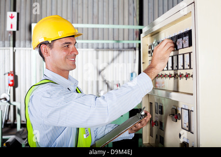 industrial machine operator adjusting machine settings Stock Photo