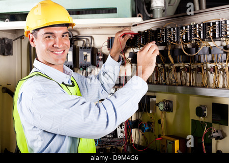 happy male electrician working on industrial machine Stock Photo