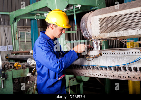 industrial mechanic repairing heavy industry machine in plant Stock Photo