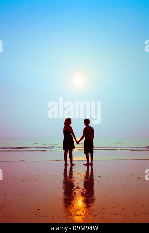 honeymoon, silhouettes of loving couple on the beach Stock Photo