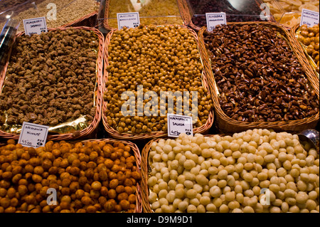 Selection of different varieties of  nuts displayed on a stall in wicker baskets in La Bouqueria market Barcelona Spain Stock Photo