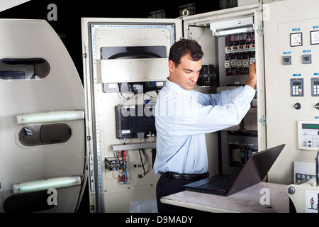 industrial technician repairing modern computerized machine in factory Stock Photo