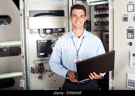 portrait of male industrial engineer in front of machinery Stock Photo