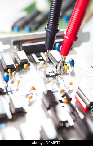 Multimeter examining a circuit board Stock Photo