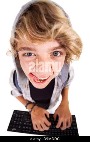 overhead view of a naughty teen boy playing on computer keyboard Stock Photo