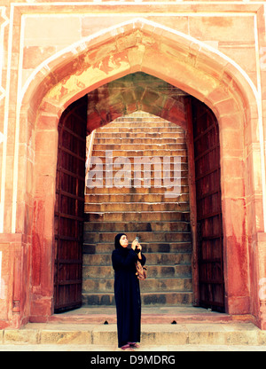 Muslim woman standing at the main door of the safdarjang tomb, new delhi Stock Photo