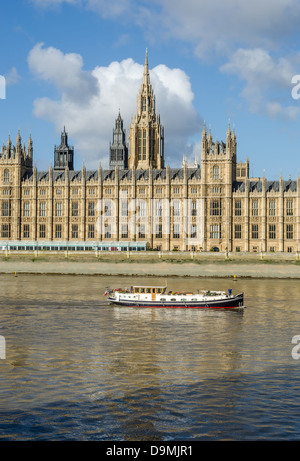 Houses of Parliament, and a boat on the Thames River. London, England. Stock Photo