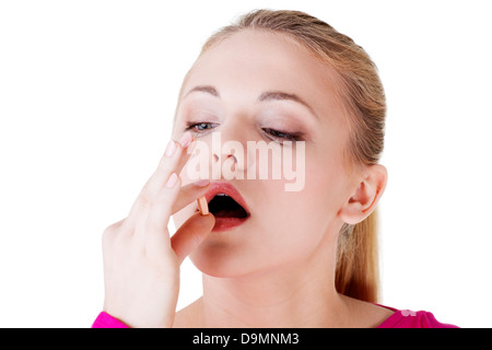 Blond woman taking pill, isolated on white. Stock Photo