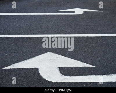 White arrows painted on tarmac Stock Photo