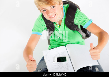 teen boy giving thumbs up while reading book Stock Photo