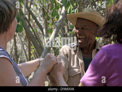 An 80-year old musician wears a traditional straw hat as talks to and dances with a group of tourists during an excursion near the town of Cienfuegos, Cuba, 14 April 2013. Photo:Peter Zimmermann Stock Photo
