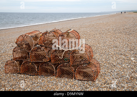 Lobster and Crab Creels, and distant figures on the almost empty Blakeney Beach, Norfolk, UK Stock Photo