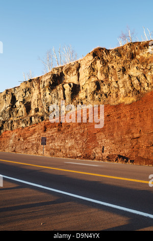 Road cut along highway 61 in northern Minnesota showing a basaltic lava flow on top of an underlying sedimentary deposit. Stock Photo
