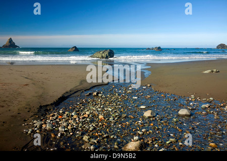 OREGON - Small creek crossing the sand on Lone Ranch Beach at the edge of the Pacific Ocean in Samuel H. Boardman State Park. Stock Photo