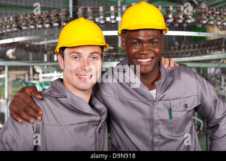 two friendly industrial workers colleagues in factory Stock Photo