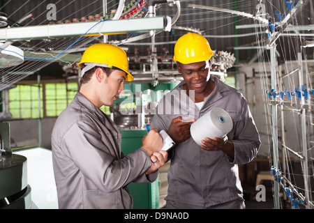 two textile workers discussing work in factory Stock Photo