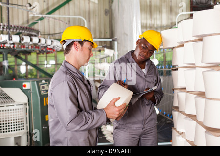 two textile workers checking raw material yarn Stock Photo