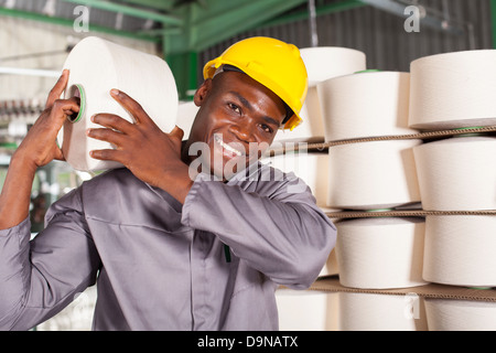 textile factory worker carrying raw material on his shoulder Stock Photo