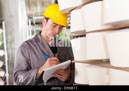 textile worker taking stock in factory Stock Photo