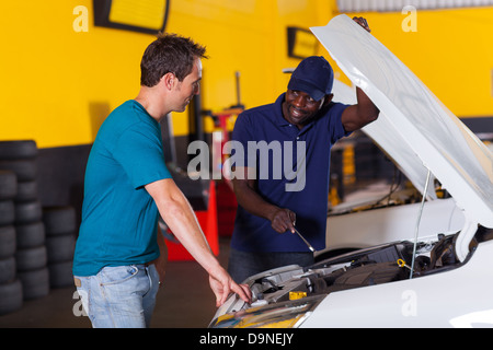 African auto mechanic and customer discussing vehicle fault Stock Photo