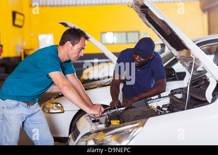 man sending his car for repair in garage Stock Photo