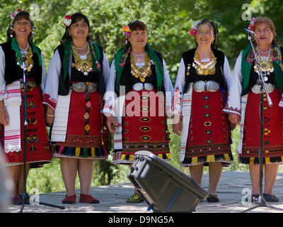 Men women children dressed in traditional national costumes singing competition entertain visitors and travellers, Bulgaria Stock Photo