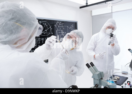 general-view of three scientists in a chemistry lab manipulating lab tools, testing and using chemical techniques around a lab t Stock Photo