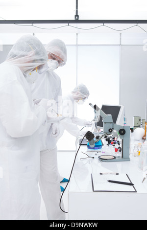 general-view of three scientists in a chemistry lab manipulating lab tools, testing and using chemical techniques around a lab t Stock Photo