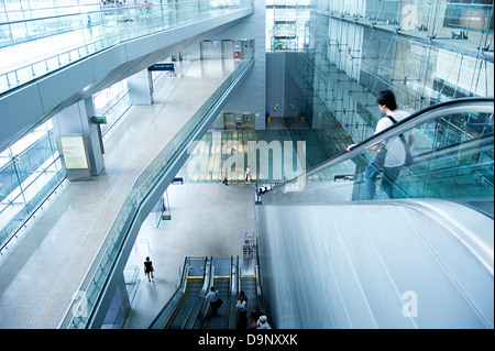 People on escalators at Changi International Airport on in Singapore. Stock Photo
